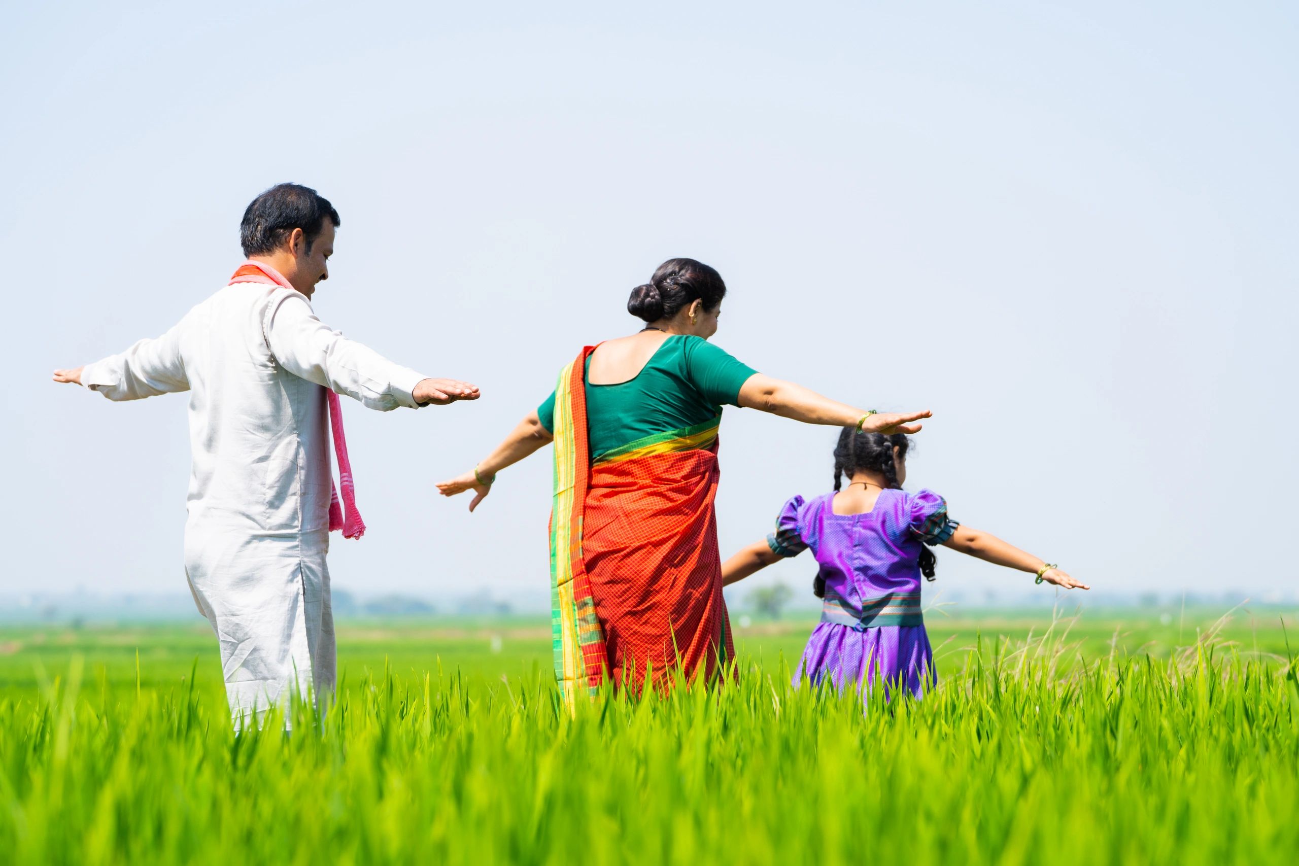 Family walking together along farmland in rural India