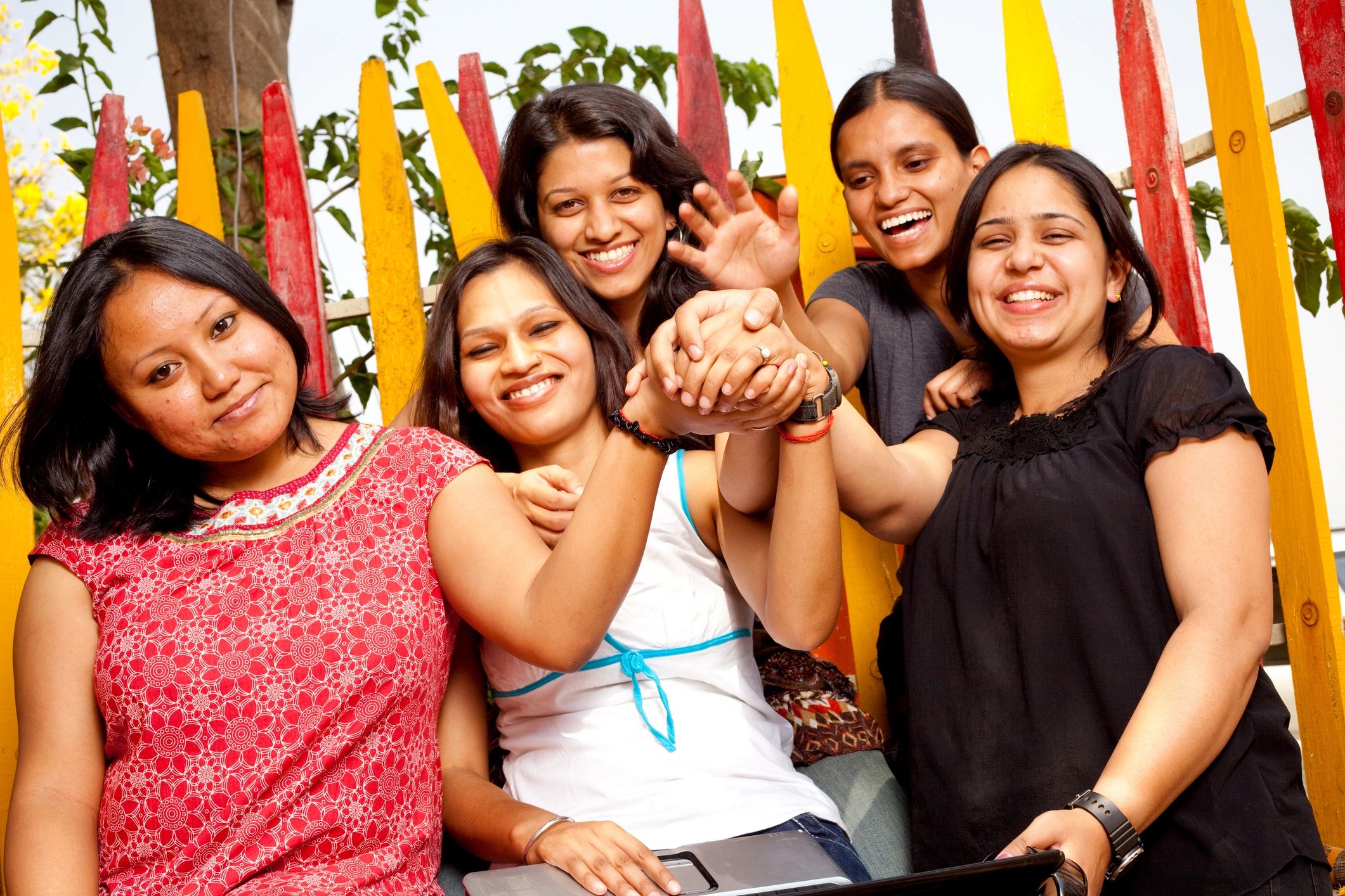 Women joining hands in a group meeting